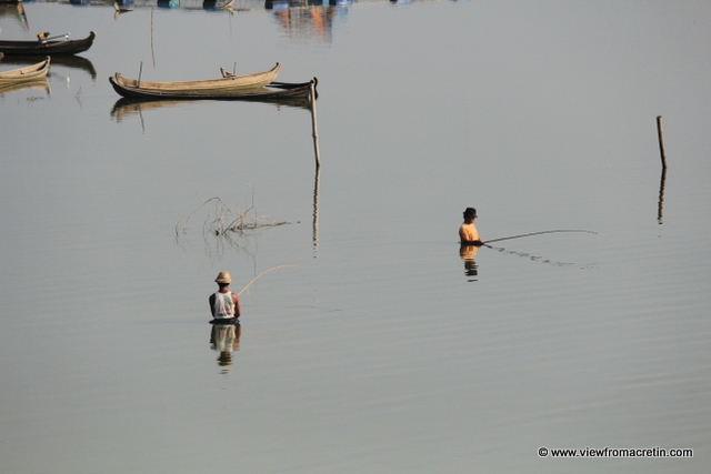 Fisherman wade out from nearby U Bein's Bridge in Amarapura as the sun sets overhead.